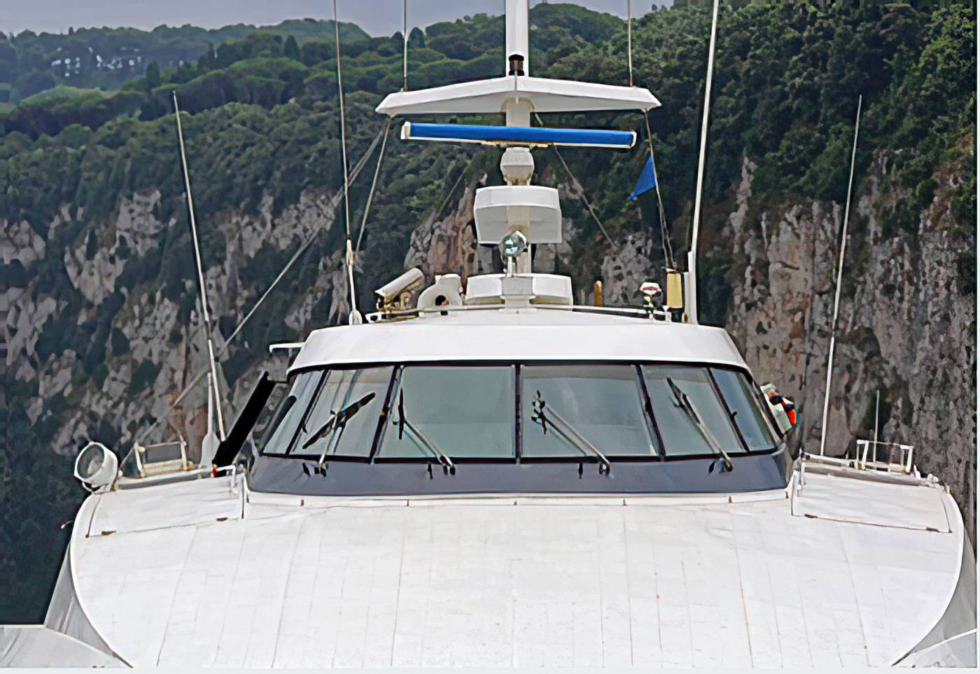 Sportfish hardtop with fitted glazing, moored under cliffs